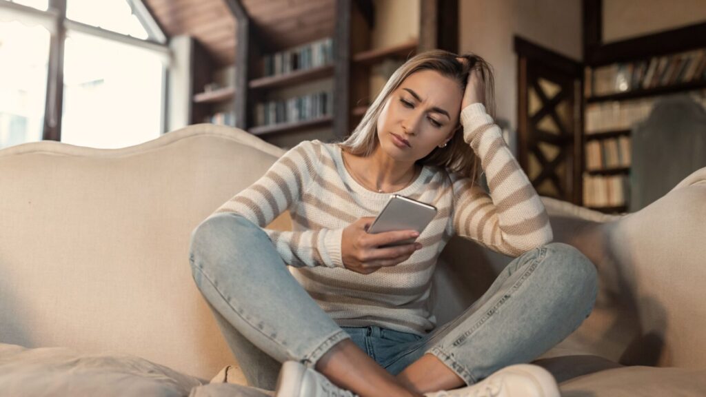 woman looking at phone, worried expression